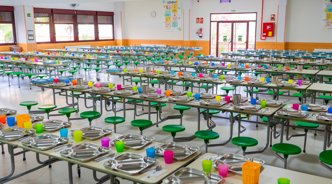 Fotografía del Comedor del Colegio El Valle de Las Tablas con las mesas ordenadas y las bandejas donde comen los alumnos colocadas sobre la mesa.